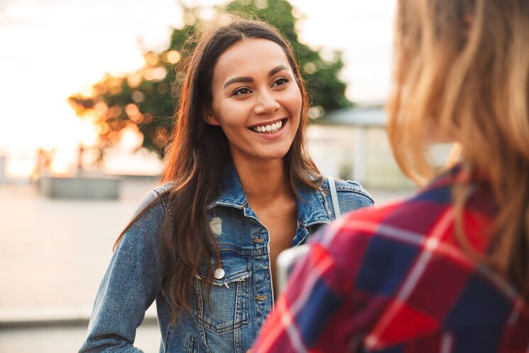 Close up of a smiling asian woman talking to her girl | Vadym Drobot