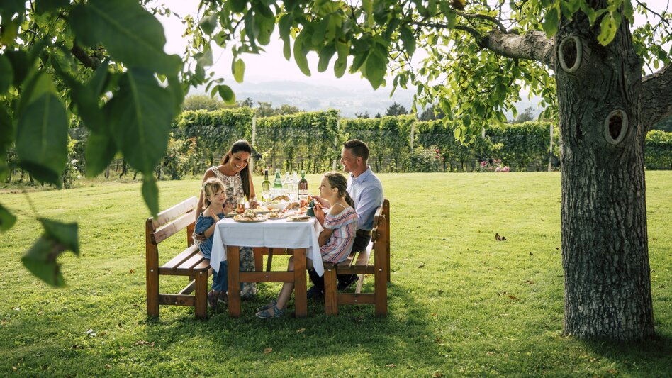 Family is dining under a walnut tree in Eastern Styria | © Steiermark Tourismus | Bernhard Bergmann